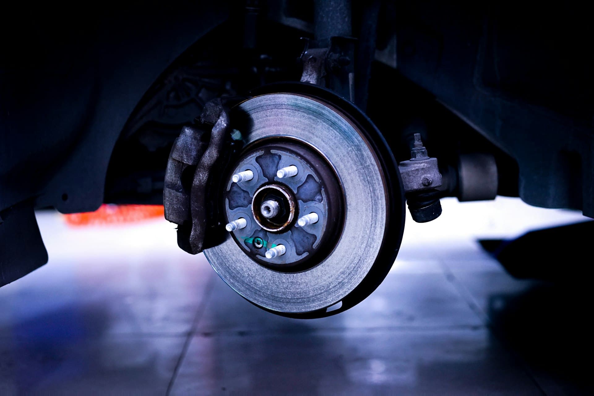 Brake disc and caliper on a raised car with the wheel removed